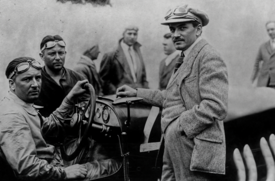 Ο Ferdinand Porsche (όρθιος, με το καπέλο) δίπλα σε αγωνιστικό αυτοκίνητο της Mercedes, στα χρόνια που δούλευε στη Daimler.