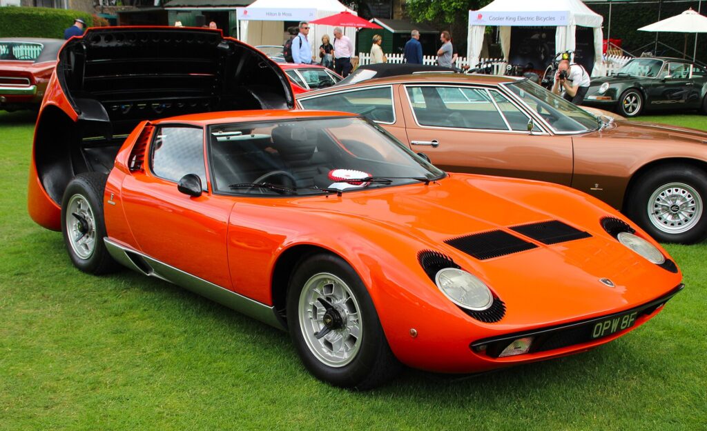 Μια Miura P400 με ανοιχτά τα μπροστινά και πίσω καπό. Ο V12 κάθεται εγκάρσια πίσω από τους επιβάτες.